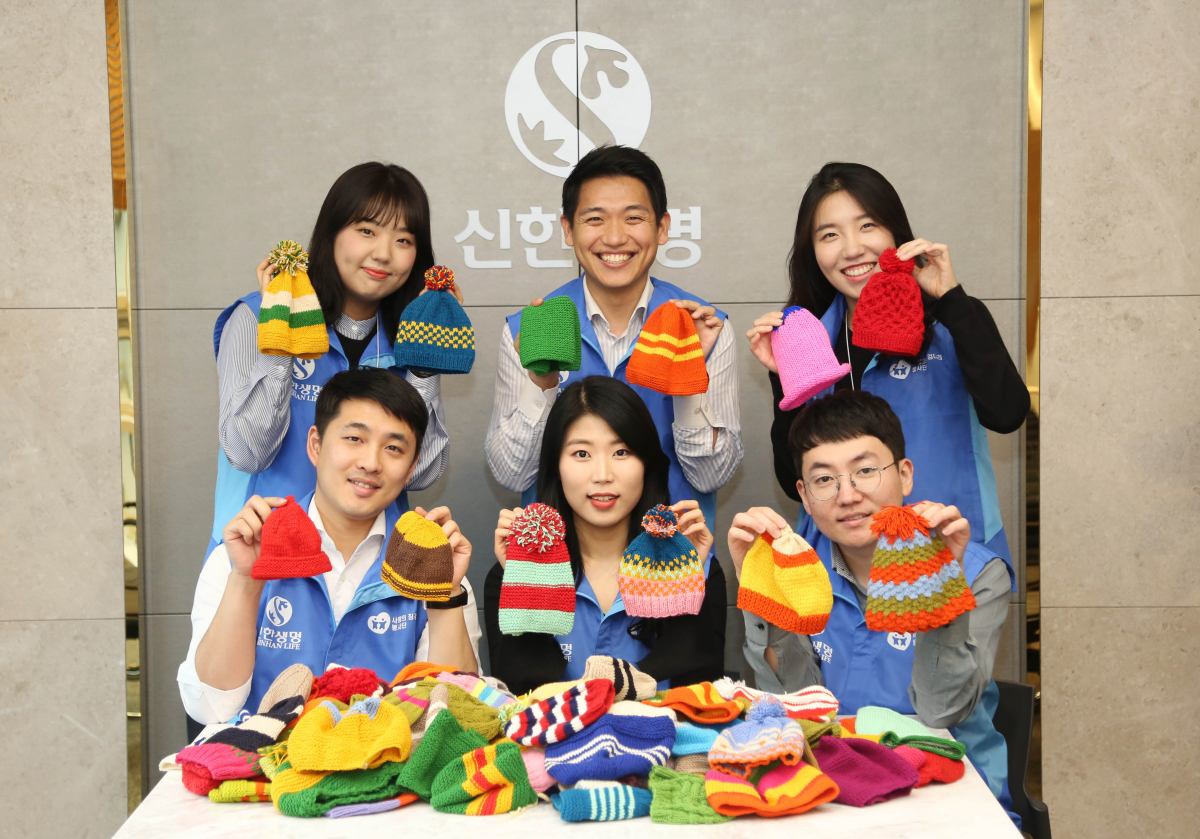 ▲신한생명 직원들이 13일 신생아 털모자를 국제아동구호단체 세이브더칠드런에 전달하고 기념촬영을 하고 있다.(사진제공=신한생명)