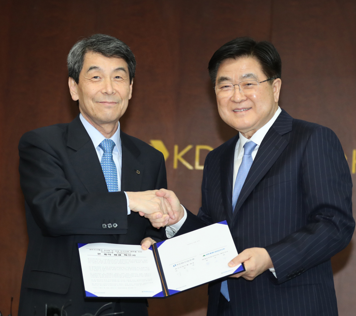 ▲현대중공업지주 권오갑(오른쪽) 부회장과 KDB산업은행 이동걸 회장이 현대중공업의 대우조선해양 인수 협약서에 서명 후 기념촬영을 하고 있다.(뉴시스)