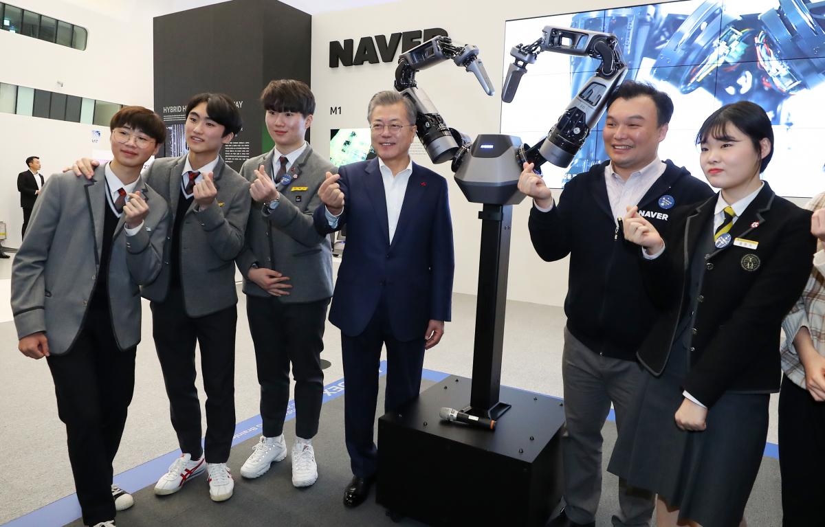 ▲문재인 대통령이 1월 서울 동대문디자인플라자에서 열린 한국 전자 IT산업 융합 전시회에서 네이버랩스의 지능형 로봇팔과 함께 기념촬영하고 있다.(뉴시스)