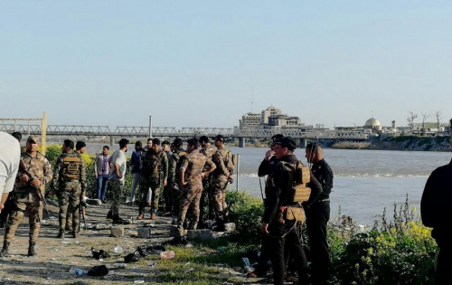 ▲이라크 모술 근처 티그리스강에서 21일(현지시간) 페리가 침몰한 가운데 군인들이 구조 작업을 위해 강변에 대기하고 있다. 모술/EPA연합뉴스 
