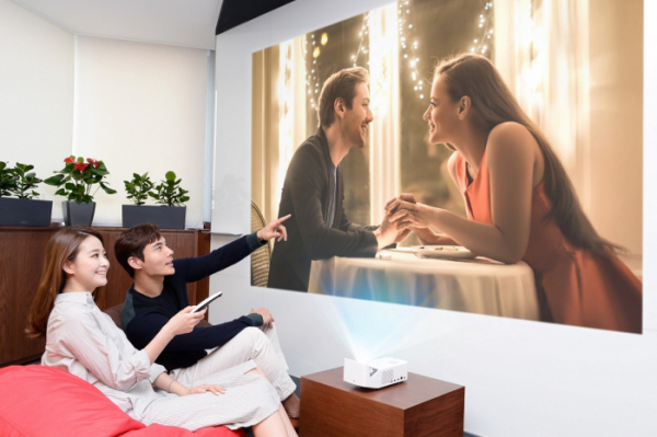 ▲모델들이 2019년형 'LG 시네빔' 프로젝터를 이용해 초대형 화면으로 영화를 시청하고 있다.(사진제공 LG전자)