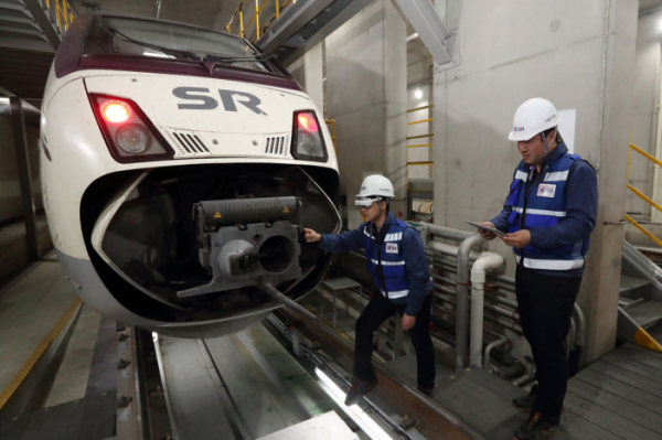 ▲수서역 SRT 정비소에서 SR 정비 직원들이 KT 5G AR 스마트안경을 이용해 열차를 정비하고 있다.(출처=KT)