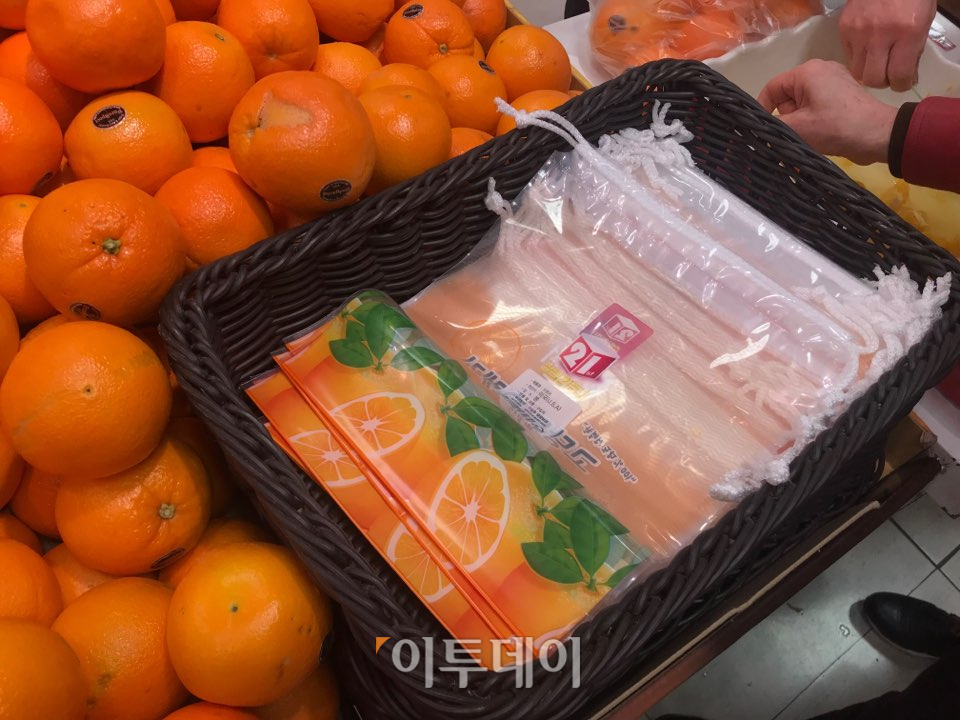 ▲오렌지 판매대 앞에는 오렌지를 담을 수 있는 오렌지 전용 봉투가 마련돼 있었다. 오렌지를 구매하지 않아도 가져갈 수 있게 놓여 있어, 종이봉투를 따로 구매하지 않고 해당 봉투를 이용해 물건을 담는 손님도 있었다. (나경연 기자 contest@)