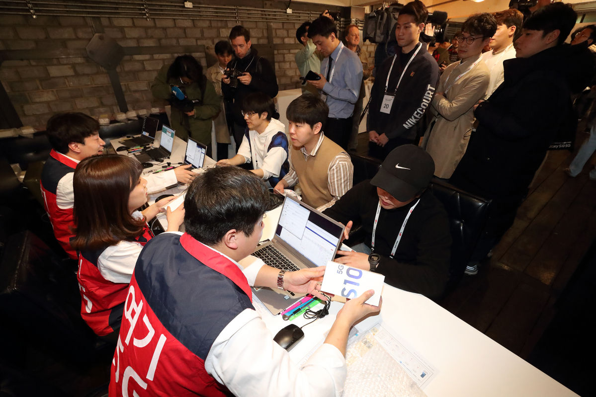 ▲‘갤럭시S10 5G’ 출시행사에 참여한 고객들이 갤럭시S10 5G 단말을 개통하고 있다.(사진제공= KT)