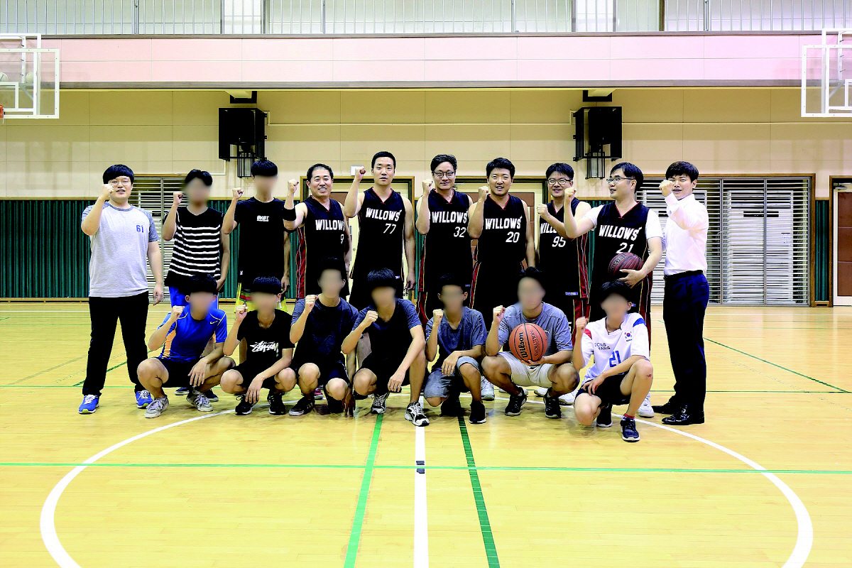 ▲유한양행 농구 동아리 윌로우 회원들과 성로원 아이들이 농구 코트에서 기념 사진을 촬영하고 있다.