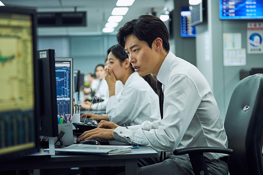 ▲일현(류준열 분)은 입사 후 첫 거래에서부터 실수하면서 팀원들의 질타를 받는다. 함께 입사한 동기 전우성(김재영 분)은 집안 배경도 좋고 얼굴도 잘생긴 '금수저'로, 계속 일현의 비교 대상이 된다. (사진제공=쇼박스)