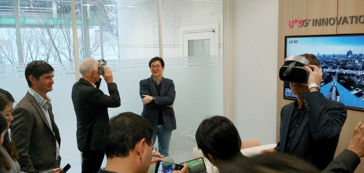 ▲ 폴 해리스 회장 등 레인 임원들이 LG유플러스 마곡사옥 1층에 마련된 ‘U+ 5G 이노베이션 랩’에서 U+ 5G 서비스를 살펴보고 있다.(사진제공= LG유플러스)