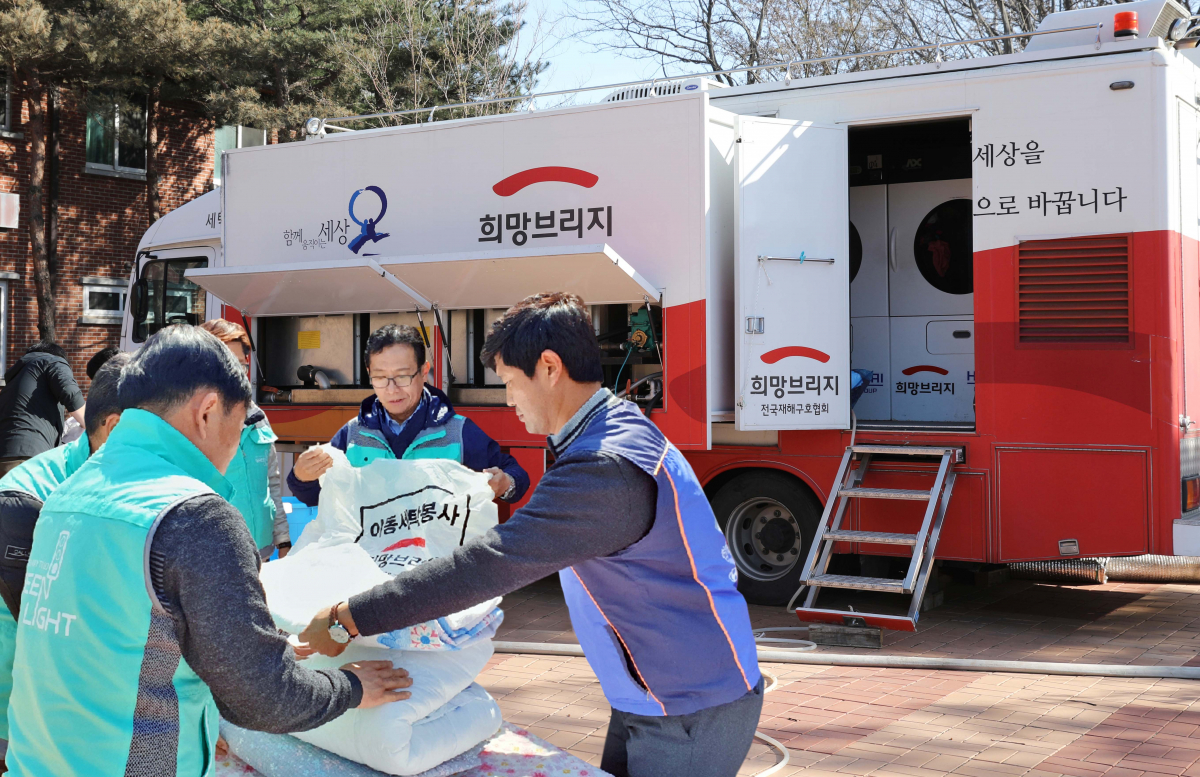 ▲현대ᆞ기아차 임직원들이 강원도 산불 피해 지역에 투입된 현대차그룹의 ‘도시형 세탁구호차량’과 함께 세탁 봉사를 하고 있는 모습. (사진제공=현대차)