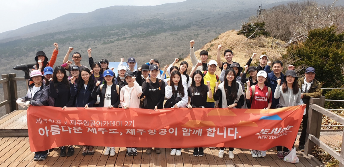 ▲4월20일 제주항공 임직원들과 제주항공 아카데미 2기 학생들이 한라산 사라오름 전망대에서 수거한 쓰레기를 들고 기념촬영을 하고 있다.(사진 제공=제주항공)