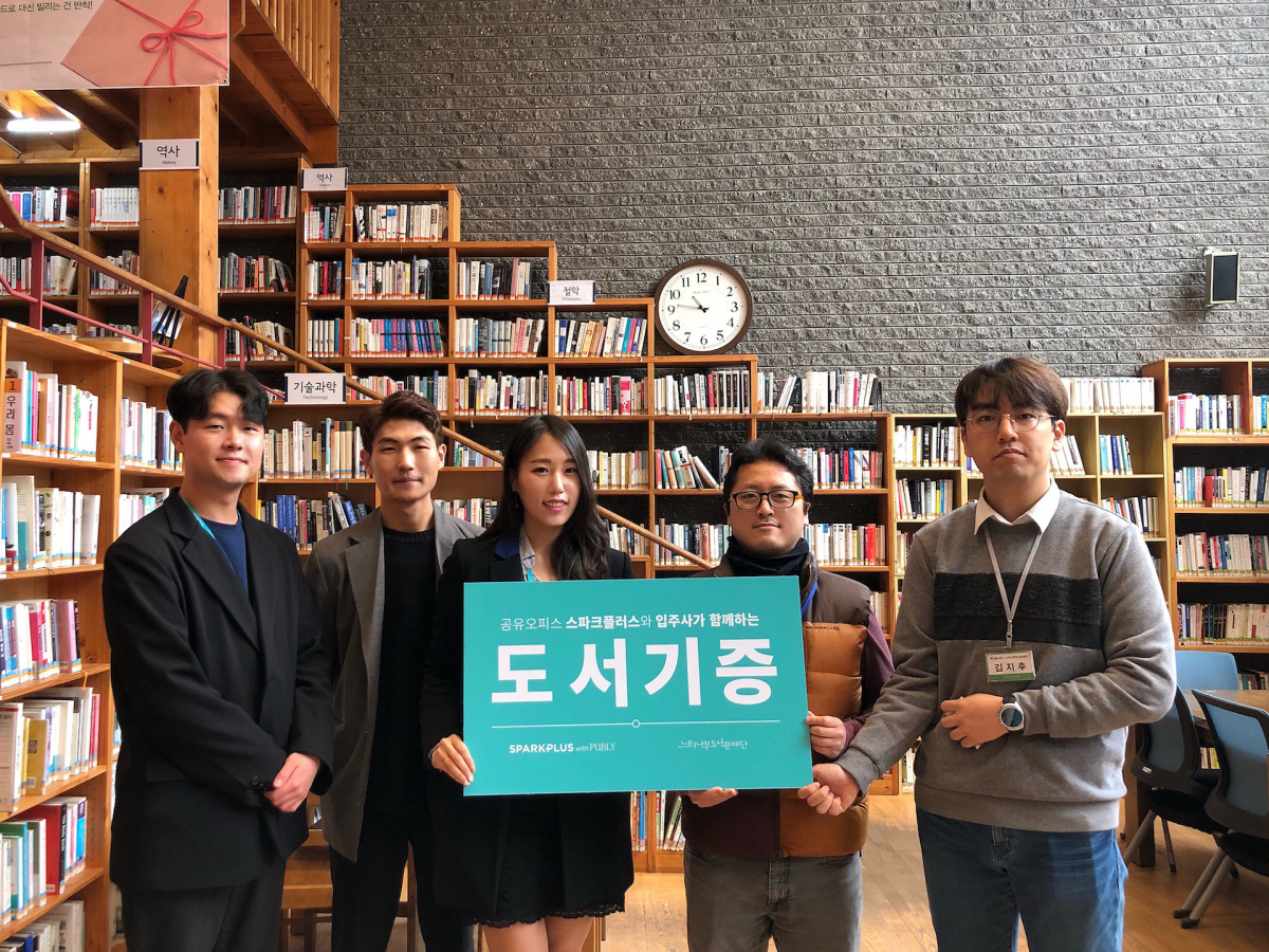 ▲19일 스파크플러스 관계자들이 느티나무도서관에 도서 기증 기념사진을 찍고 있다.(사진=스파크플러스)