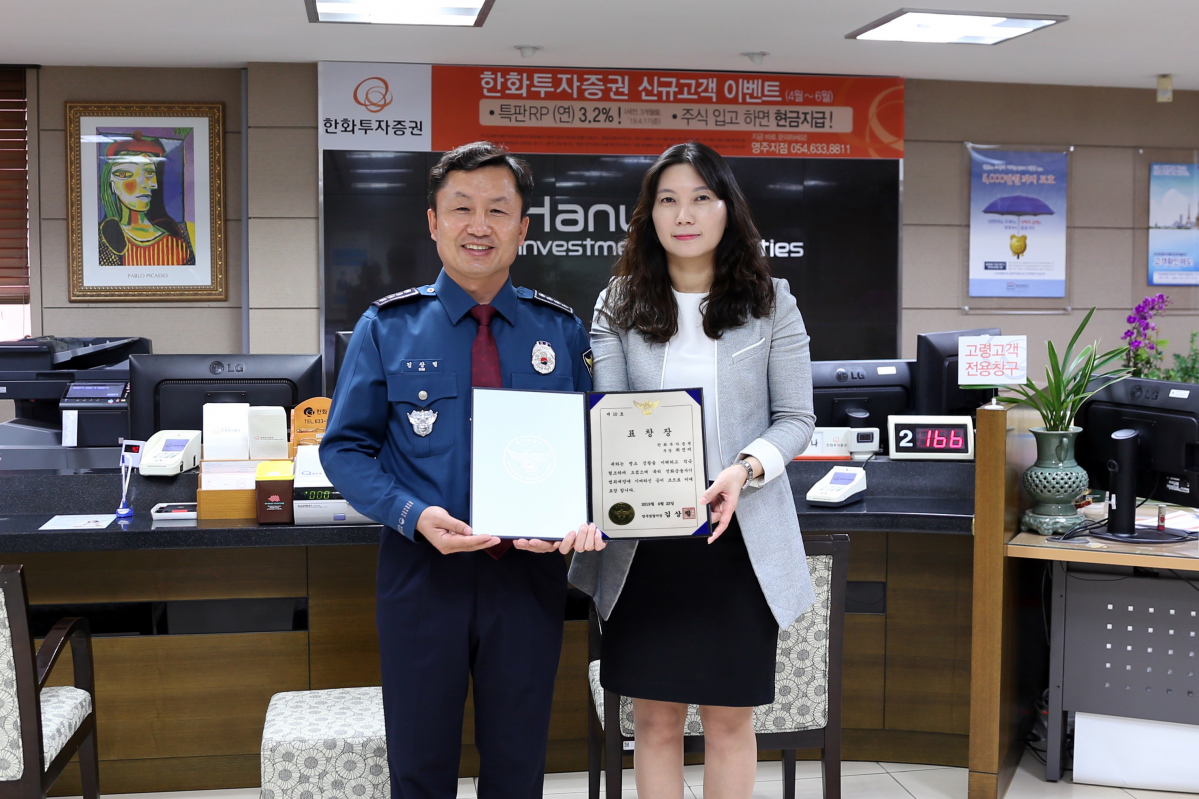 ▲한화투자증권 영주지점 최진미PB가 고객의 보이스피싱 피해를 막아 23일 영주경찰서로부터 표창장을 받고, 김상렬 영주경찰서장과 기념촬영을 하고 있다.(한화투자증권)