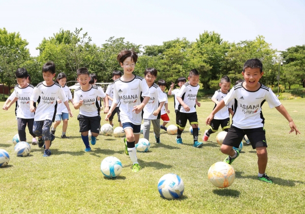 ▲아시아나항공이 지난해 임직원 자녀 60여 명을 대상으로 연 ‘아시아나 축구교실’에 참가한 어린이들이 축구경기를 하고 있다. 사진제공 금호아시아나그룹