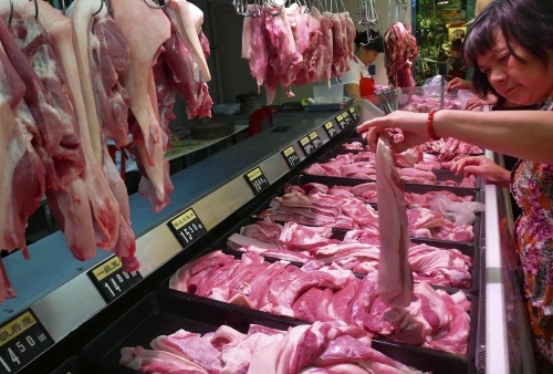 ▲중국 후베이(湖北)성 이창(宜昌)시의 한 시장에서 한 고객이 돼지고기를 살펴보고 있다. 이창/AP뉴시스

