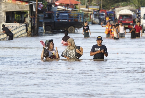 ▲인도네시아 수마트라섬 남서부 븡쿨루주에 집중호우로 홍수가 나 주민들이 허리까지 물이 찬 도로를 건너고 있다. 븡쿨루/AP뉴시스

