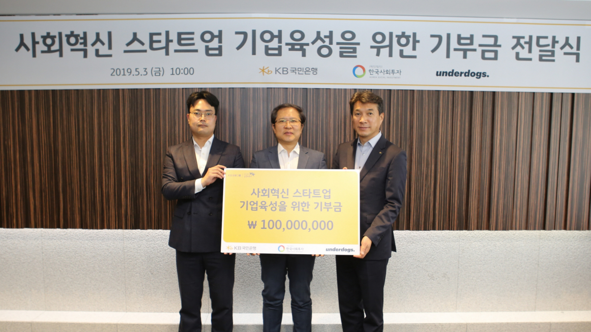 ▲(왼쪽부터)조상래 주)언더독스 대표, 이종익 한국사회투자 대표, 성채현 KB국민은행 소비자브랜드전략그룹 대표가 3일 서울 여의도 국민은행 본점에서 열린 기부금 전달식에서 기념촬영을 하고 있다.(사진제공=KB국민은행)