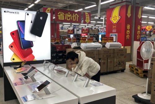 ▲9일(현지시간) 베이징에 있는 가전매장의 애플 코너에서 한 중국 소비자가 아이폰을 들여다 보고 있다. 베이징/AP연합뉴스

