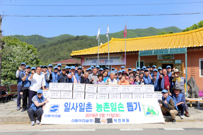 ▲신동아건설 임직원 50여명이 지난 11일 강원도 영월 덕전마을을 찾아 마을 주민들과 함께 기념촬영을 하고 있다(사진=신동아건설)