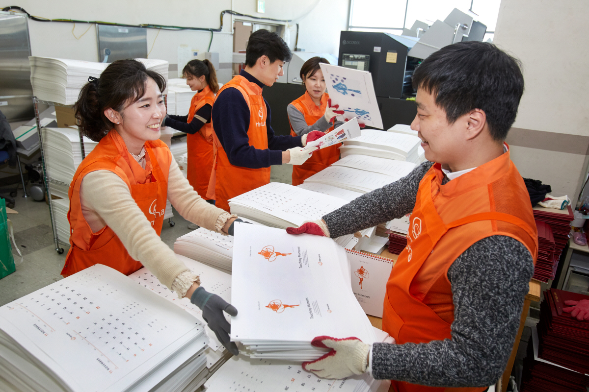 ▲한화그룹 직원들이 조판, 인쇄가 완료된 인쇄물을 재단, 타공하기 위해 옮기고 있다. 사진제공 한화그룹