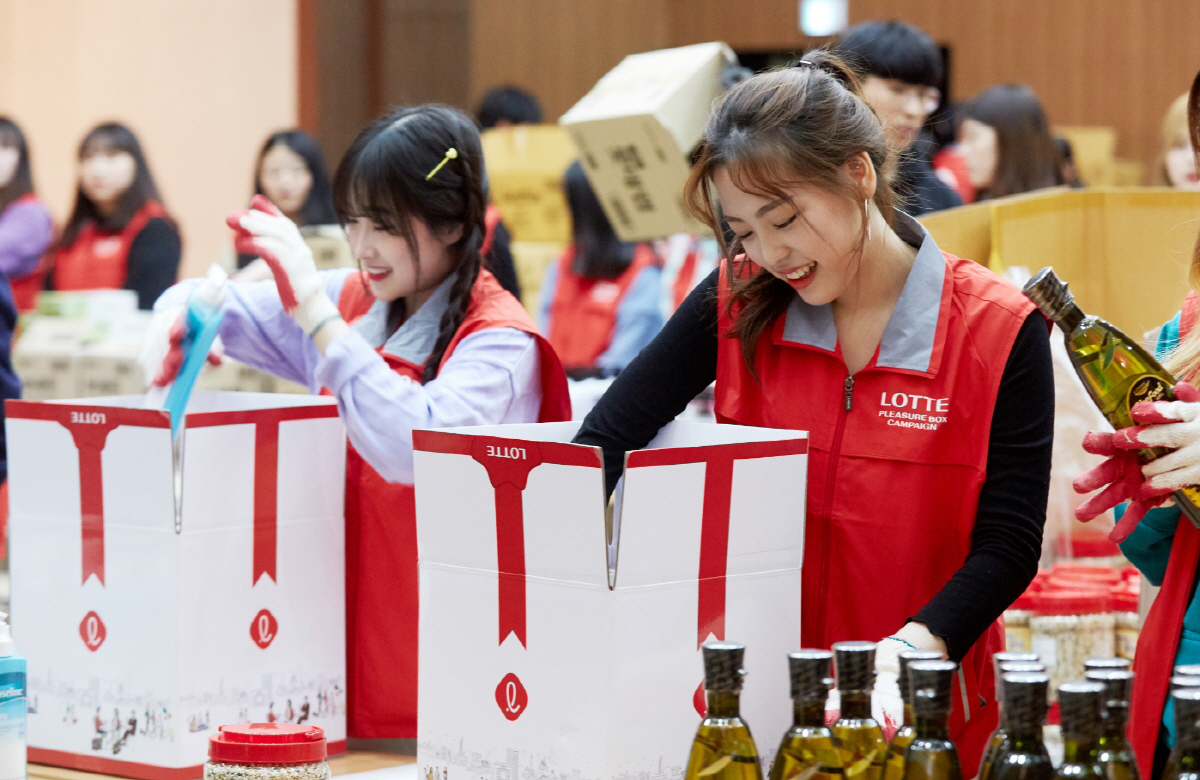 ▲롯데는 저소득층 여학생들에게는 생리대를, 시각장애인에게는 점자도서를 지원하는 플레저박스 캠페인을 진행 중이다. 임직원이 플레저박스를 포장하고 있다.  사진제공 롯데지주