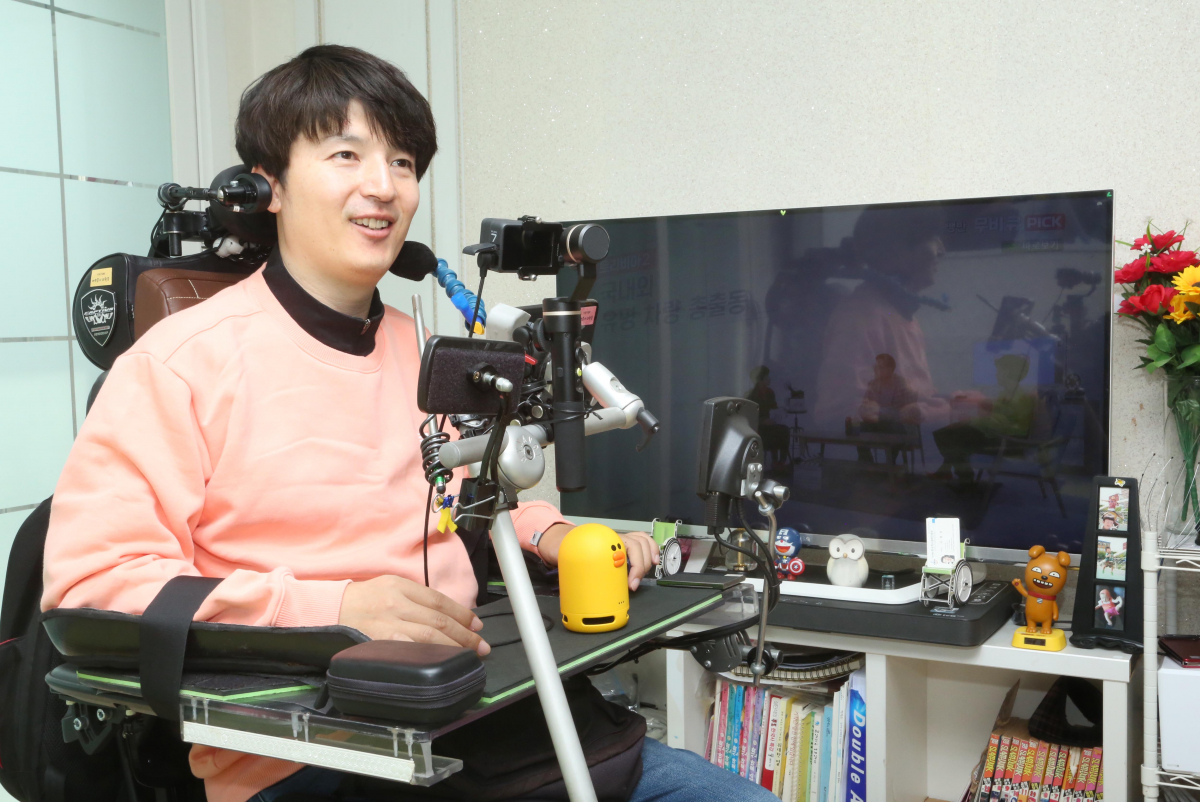 ▲척수장애인 이원준 씨가 ‘U+우리집AI’ 서비스를 이용해 음성명령으로 장애인 콜택시를 호출하고 있다.(사진제공= LG유플러스)