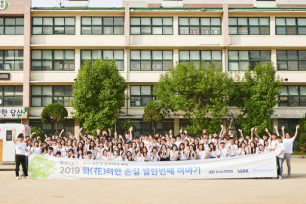 ▲‘화(花)려한 손길 캠페인’ 열한 번째 프로젝트에 참가한 봉사자들이 당산초등학교 운동장에서 기념촬영을 하고 있다. 사진제공 현대자동차