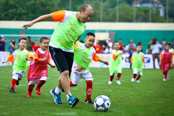 ▲축구교실을 지도한 박항서 감독이 베트남 아이들과 축구 미니게임을 즐기고 있다.(사진 제공=현대오일뱅크)