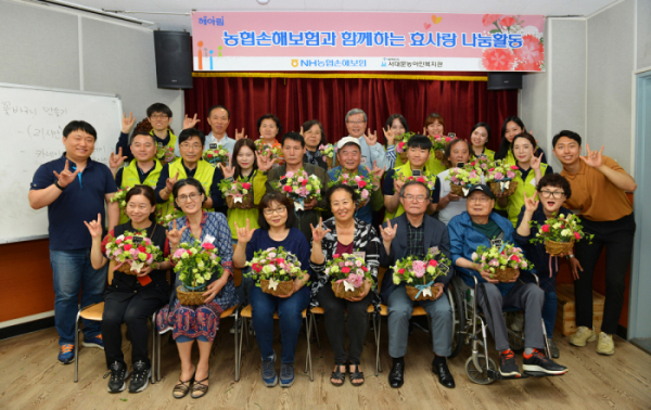 ▲오병관 대표이사(사진 세 번째줄 왼쪽에서 다섯번째)와 헤아림 봉사단원들이 청각장애어르신들과 함께 기념촬영을 하고 있다.(사진제공=NH농협손해보험)