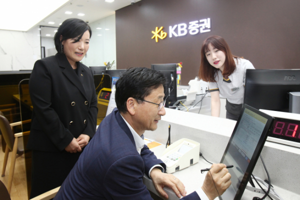 ▲27일 KB증권 박정림 사장(왼쪽)과 한국주택금융공사 이정환 사장(가운데)이 KB증권 여의도 영업부를 방문해 디지털창구를 통해 MBS 매수를 하고 있다.