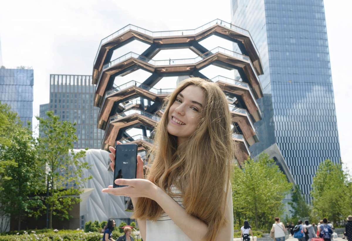 ▲LG전자 모델이 미국 뉴욕의 새로운 랜드마크로 떠오르고 있는 건축물 '베슬(Vessel)'을 배경으로 지난 31일 미국에 출시된 LG V50 씽큐를 소개하고 있다.(사진제공=LG전자)