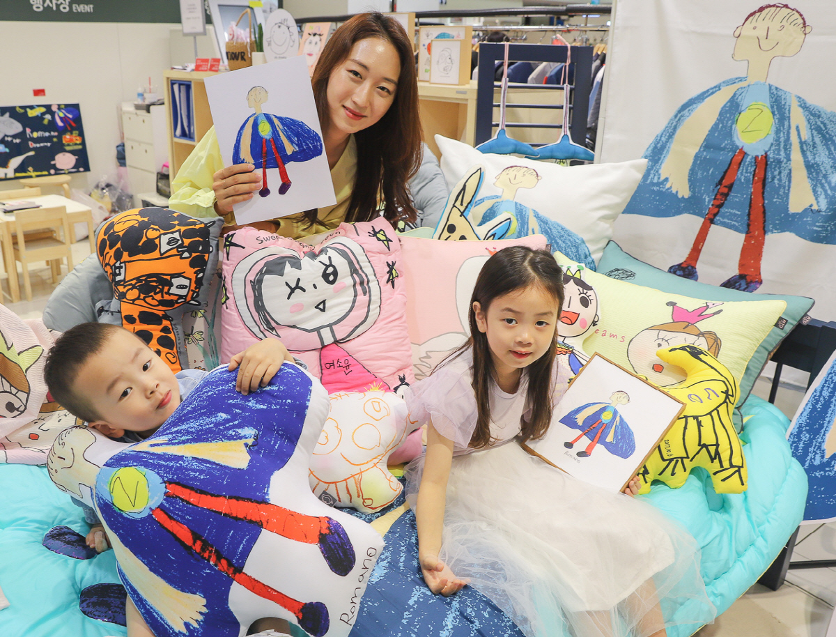 ▲4일 오전 현대백화점 중동점 6층 ‘아토 드로잉’ 팝업스토어에서 어린이 모델이 직접 그린 그림과 제작된 상품을 직원과 함께 선보이고 있다.