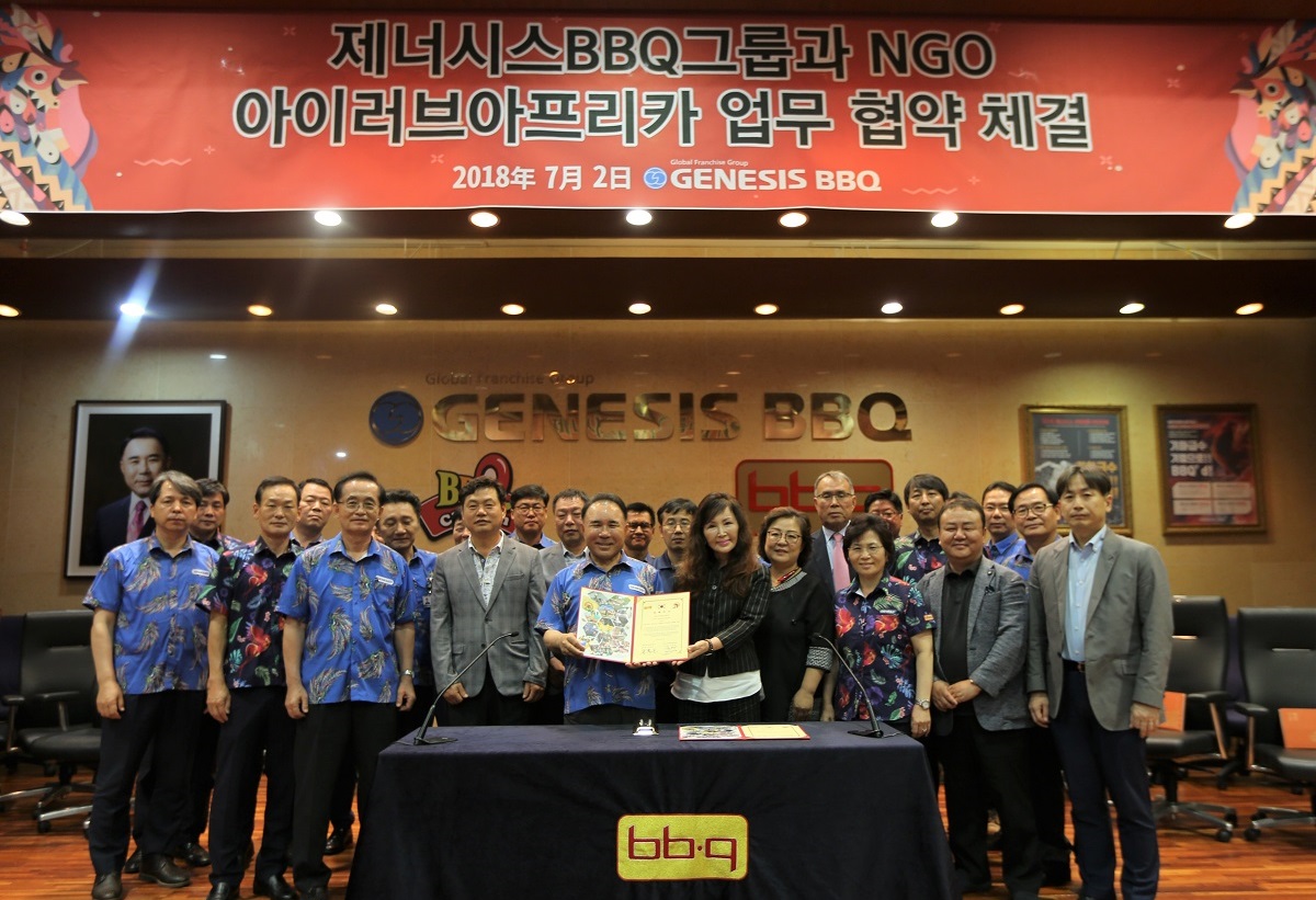 ▲지난해 7월 윤홍근 제너시스BBQ 그룹 회장(맨 앞줄 왼쪽에서 세번째) 과 이창옥 아이러브아프리카 이사장(맨 앞줄 왼쪽에서 네번째) 이 업무협약을 체결하고 있다.(제너시스BBQ)