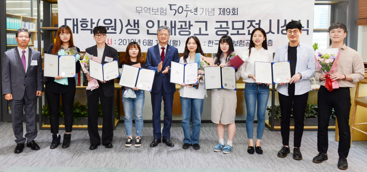 ▲무역보험 50주년 대학생 인쇄광고 공모전 수상자들이 이인호 한국무역보험공사 사장(왼쪽 다섯 번째)과 기념촬영을 하고 있다.(출처=한국무역보험공사)