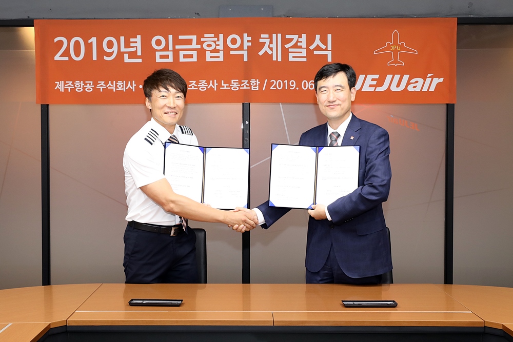 ▲박준 제주항공조종사노동조합 위원장(사진 왼쪽)과 이석주 제주항공 대표이사가 2019년 임금협약을 체결하고 악수하고 있다.(사진제공=제주항공)
