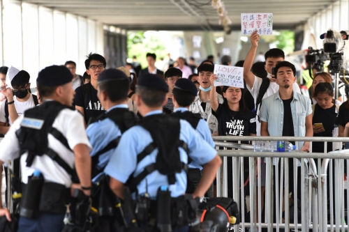 ▲홍콩 정부청사 인근에서 14일(현지시간) 시민이 시위하는 가운데 경찰들이 경비를 서고 있다. 홍콩/AFP연합뉴스
