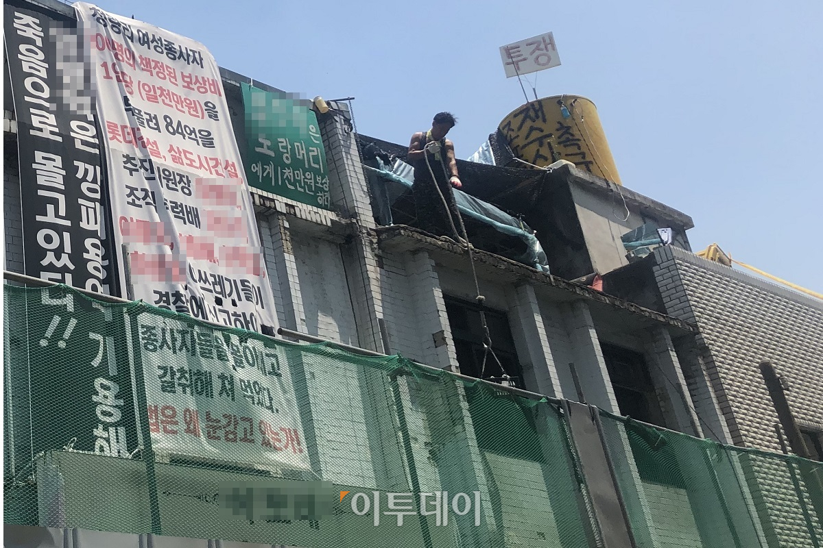 ▲연합비상대책위원회 회원이 옥상에서 5개월 째 농성하고 있다. 한 여성이 생필품을 바구니에 담아 전달하고 있다. (홍인석 기자 mystic@)