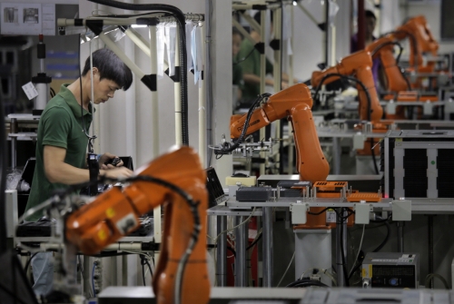 ▲중국 선전의 라푸테크놀로지 공장에서 근로자들이 로봇팔과 함께 제품을 생산하고 있다. 선전/AP뉴시스

