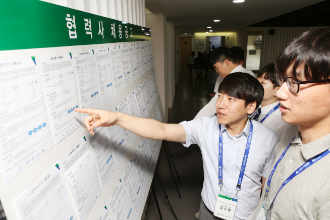 ▲채용박람회를 찾은 기술교육원 졸업생이 채용공고를 보고 있다(사진=현대건설)