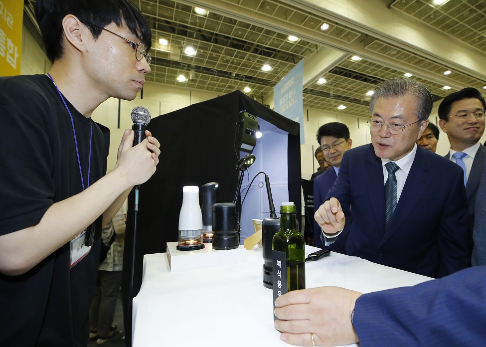 ▲문재인 대통령이 5일 오후 대전컨벤션센터에서 열린 제2회 대한민국 사회적경제 박람회 전시관을 방문, '루미르' 부스에서 설명을 듣고 있다. '루미르'는 개발도상국의 빛 부족 문제를 해결하기 위해 설립된 기업으로 양초의 열에너지를 전기에너지로 변환, LED를 밝혀 더 밝은 빛을 제공하거나 식용유를 연료로 하는 램프를 제작하고 있다.(연합뉴스)