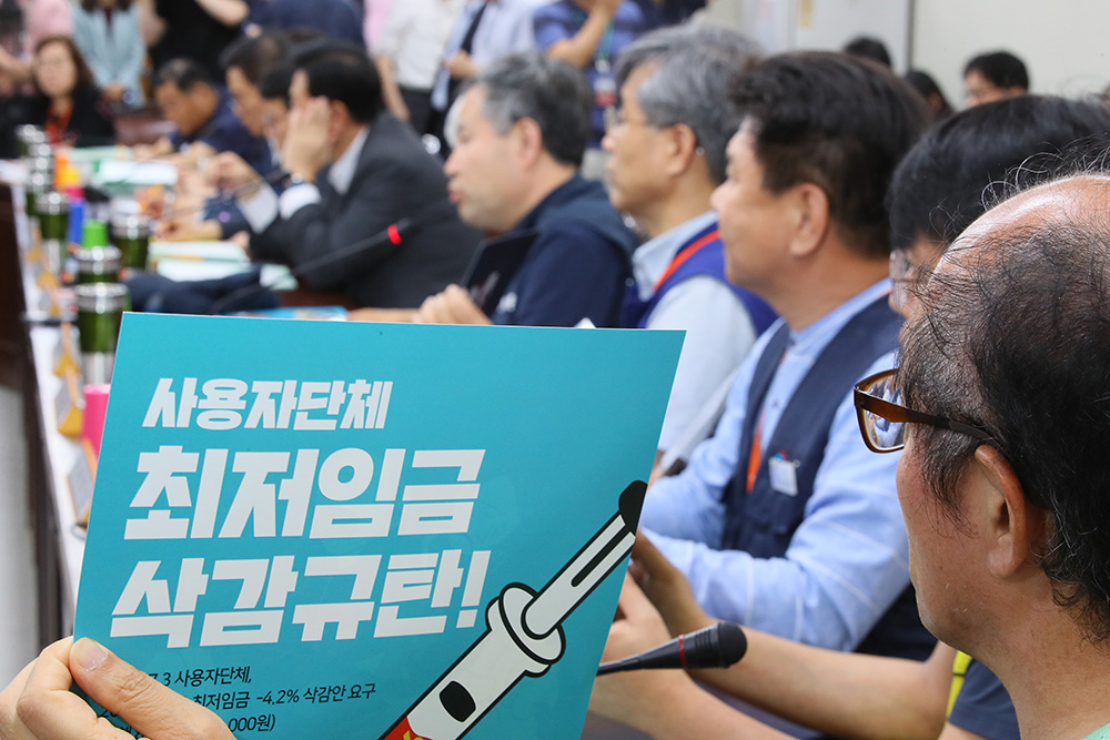 ▲노동계가 경영계의 삭감안에 반발해 불참했다 최저임금위에 복귀한 10일 세종시 정부세종청사 고용노동부에서 열린 최저임금위원회 제10차 전원회의에서 근로자 위원들이 삭감안 규탄 포스터를 들어 보이고 있다.(연합뉴스)