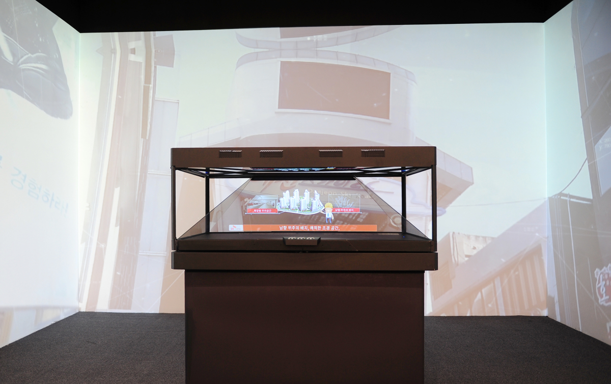 ▲SK건설은 이 달 개관 예정인 대전 ‘신흥 SK뷰(SK VIEW)’ 견본주택에 홀로그램과 가상현실(VR) 기술을 적용하고, 철거 중 발생한 폐자재를 견본주택의 마감자재와 소품으로 재활용했다. 사진은 신흥 SK뷰 견본주택의 홀로그램존과 주변 벽을 스크린으로 활용한 미디어파사드(Media Facade)(사진=SK건설)