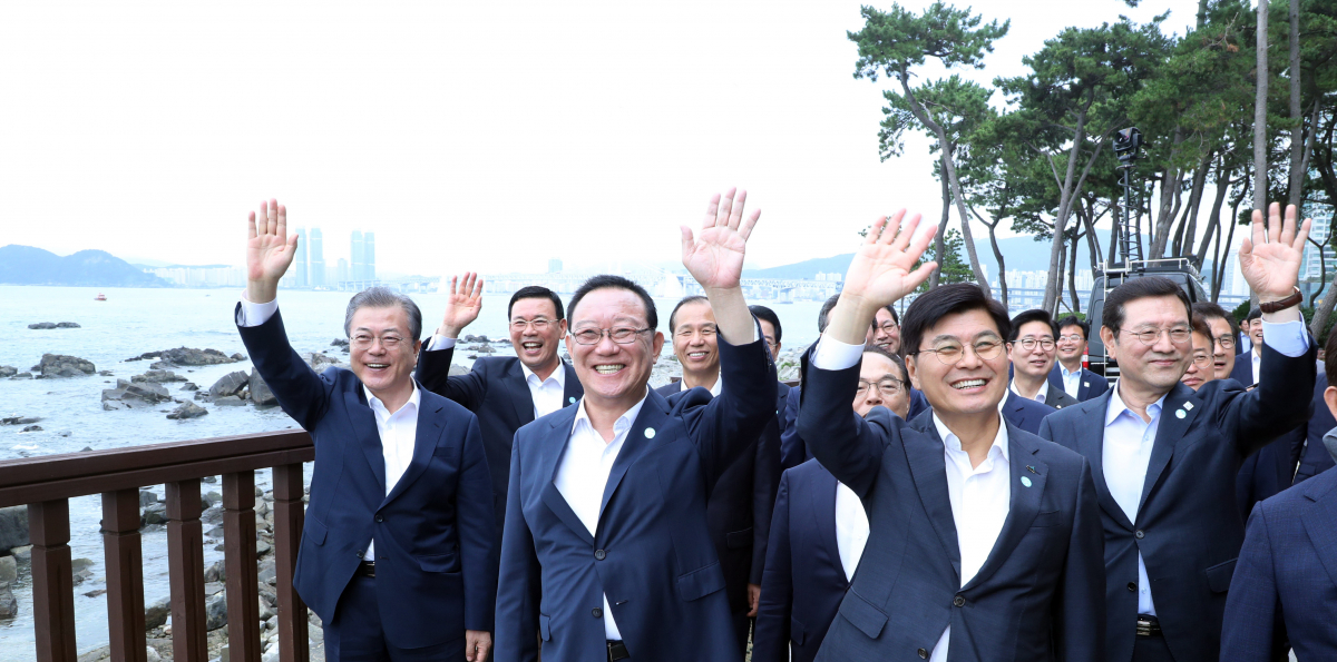 ▲문재인 대통령이 24일 부산 누리마루에서 시·도지사 간담회 참석자들과 기념촬영 뒤 시민들에게 손을 흔들고 있다.     왼쪽부터 문 대통령, 박주봉 중소기업 옴부즈만, 송철호 울산시장, 최문순 강원도지사, 오거돈 부산시장, 이춘희 세종시장.이용섭 광주시장. (연합뉴스)