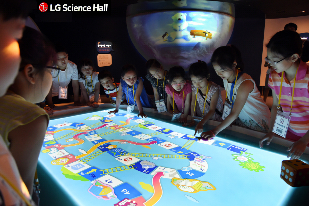 ▲LG사이언스홀을 찾은 학생들이 일상 속 행동이 지구에 미치는 영향을 직접 체험하는 ‘에코레이스’를 관람하고 있다.