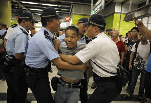 ▲홍콩의 한 지하철역에서 30일(현지시간) 시위대가 운행 방해 시위를 벌이는 가운데 분노한 한 승객이 시위대와 싸우려 하자 경찰들이 막고 있다. 홍콩/AP뉴시스 
