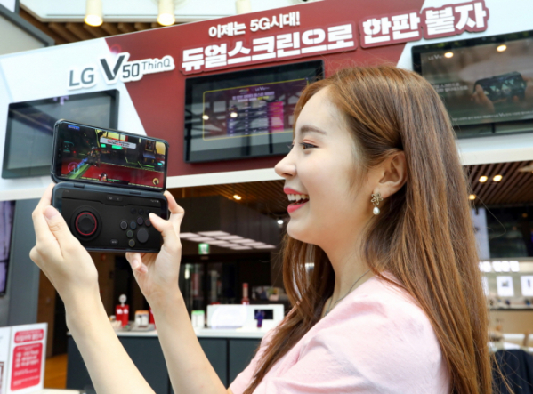 ▲LG전자 모델이 LG V50 씽큐와 LG 듀얼 스크린으로 모바일 게임을 즐기고 있다.  (사진제공 LG전자)