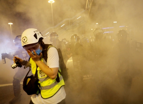 ▲홍콩에서 4일(현지시간) 경찰이 시위대를 향해 최루탄을 발사하자 한 기자가 얼굴을 손으로 감싸고 있다. 홍콩/로이터연합뉴스
