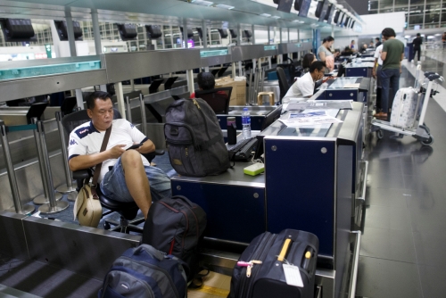 ▲홍콩 국제공항에서 12일(현지시간) 모든 비행이 취소된 가운데 승객들이 체크인 카운터에 앉아 있다. 홍콩/로이터연합뉴스
