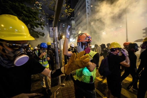 ▲홍콩 주룽반도 침사추이에서 3일(현지시간) 경찰이 최류탄을 쏜 가운데 시위자들과 의료 봉사자들이 방독면을 쓴 채 움직이고 있다. 침사추이/AFP연합뉴스 
