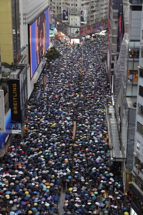▲18일(현지시간) 송환법 반대 집회에 참가한 홍콩 시민이 우산을 쓰고 도심을 행진하고 있다. (홍콩/AP연합뉴스)