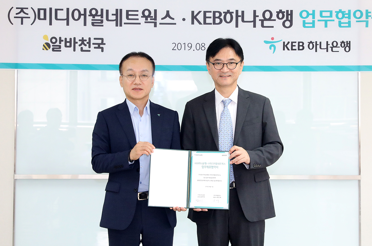 ▲김기석 KEB하나은행 서초영업본부장(사진 왼쪽)과 공선욱 미디어윌네트웍스 대표(사진 오른쪽)이 19일 서울 서초구에 위치한 KEB하나은행 서초영업본부에서 업무협약을 맺고 기념촬영을 하고 있다.(사진제공=KEB하나은행)