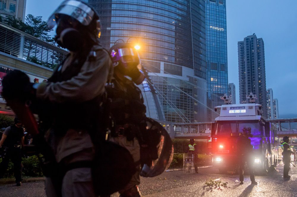 ▲홍콩 취안완구에서 25일 경찰들이 시위대를 진압하기 위한 물대포 앞에 진을 치고 있다. 블룸버그